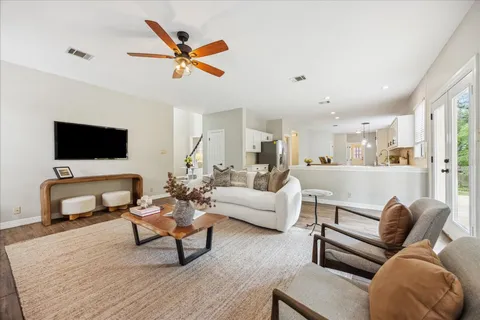 a living room with furniture and a flat screen tv with wooden floor
