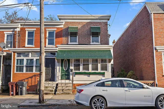 a front view of a house with car parked