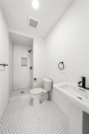 a bathroom with a sink a toilet and shower