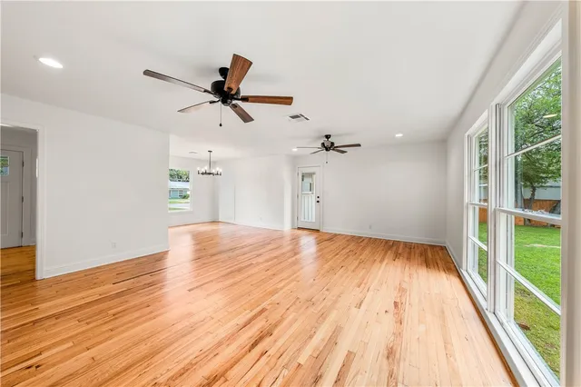 a large white kitchen with granite countertop a large window and a sink