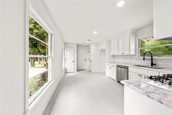 a kitchen with granite countertop white cabinets and stainless steel appliances