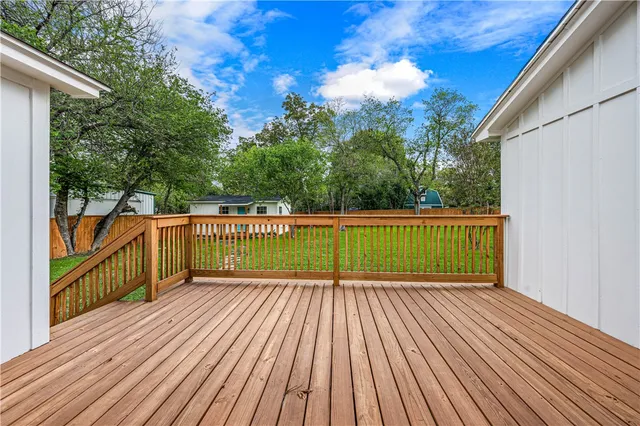 a view of a balcony with wooden floor and fence