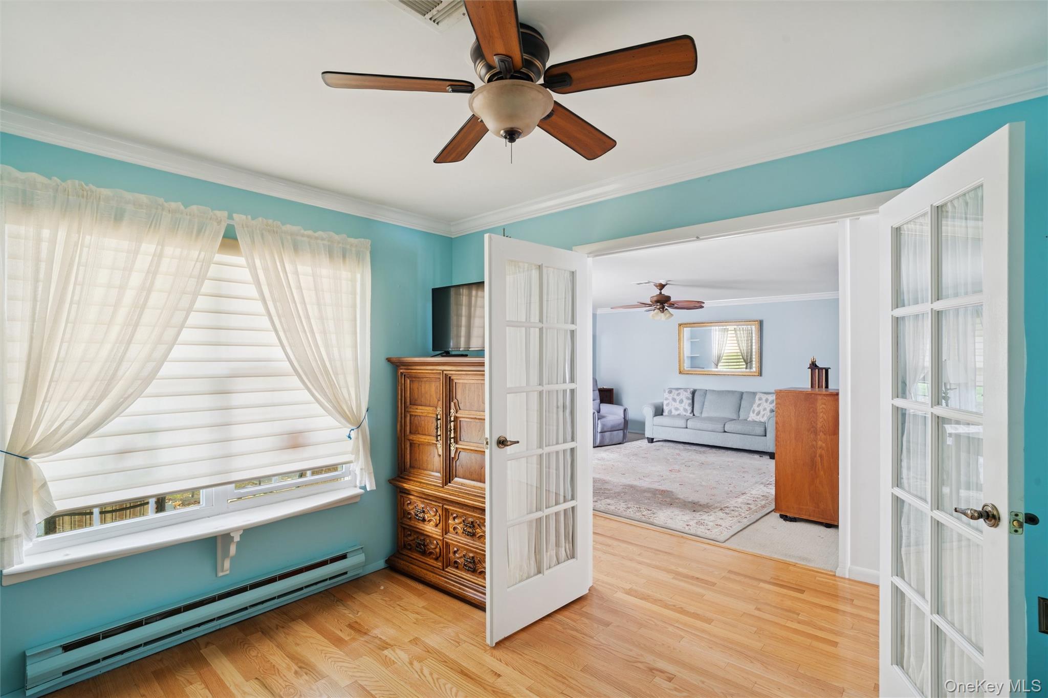 474 Darwen Drive, Unit B Ridge, NY 11961 - Photo 16 of 34 a view of an empty room with window wooden floor and a ceiling fan