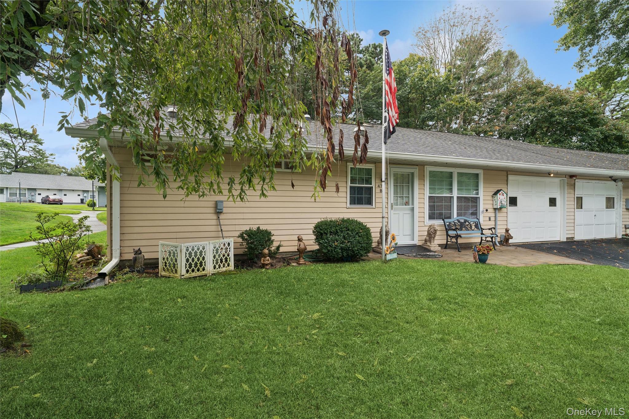 474 Darwen Drive, Unit B Ridge, NY 11961 - Photo 30 of 34 a front view of a house with garden and trees