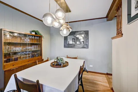 a view of a dining room with furniture a chandelier and wooden floor