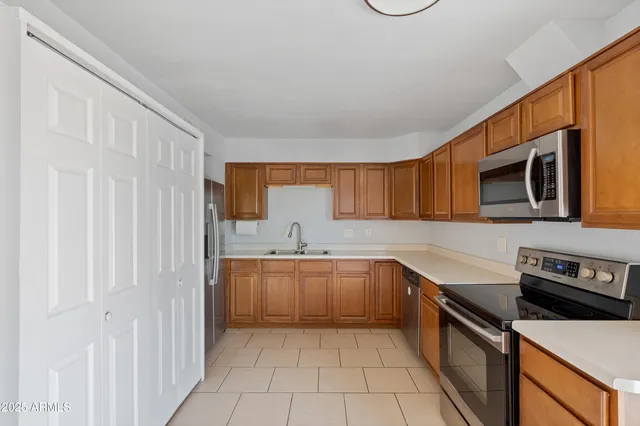 a kitchen with stainless steel appliances granite countertop a sink and dishwasher a stove top oven with wooden floor