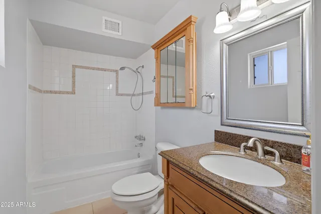 a bathroom with a granite countertop sink toilet a mirror and shower
