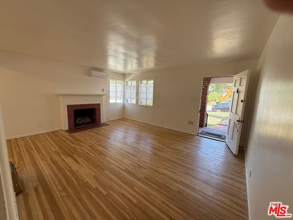3237 Midvale Avenue Los Angeles, CA 90034 - Photo 3 of 24 an empty room with wooden floor fireplace and windows