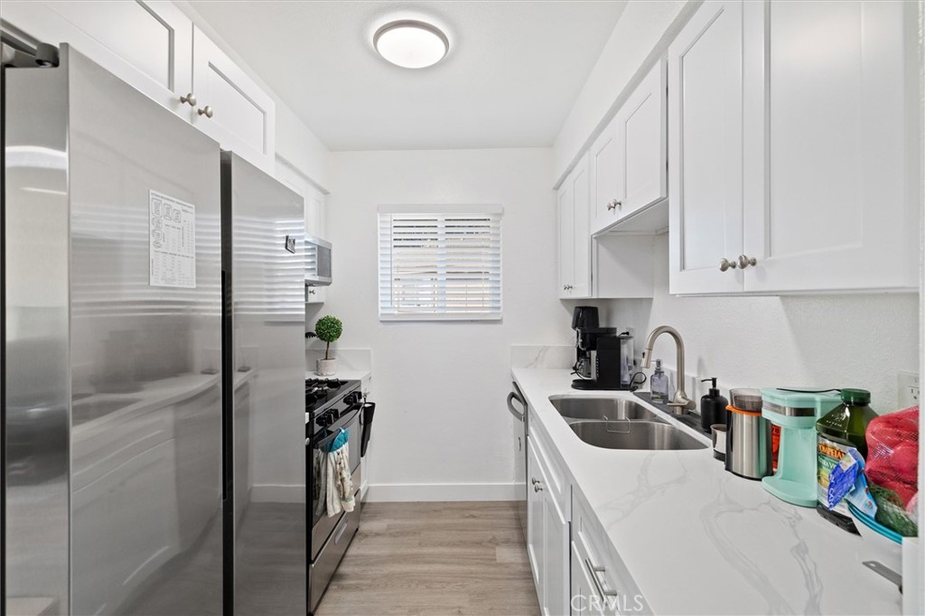 1723 Normandy Place, Unit D Santa Ana, CA 92705 - Photo 1 of 18 a kitchen with stainless steel appliances a sink a refrigerator and cabinets