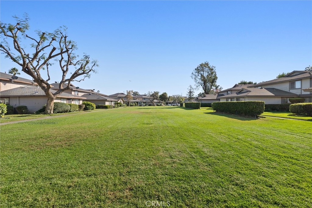 1723 Normandy Place, Unit D Santa Ana, CA 92705 - Photo 15 of 18 a view of yard with swimming pool and green space