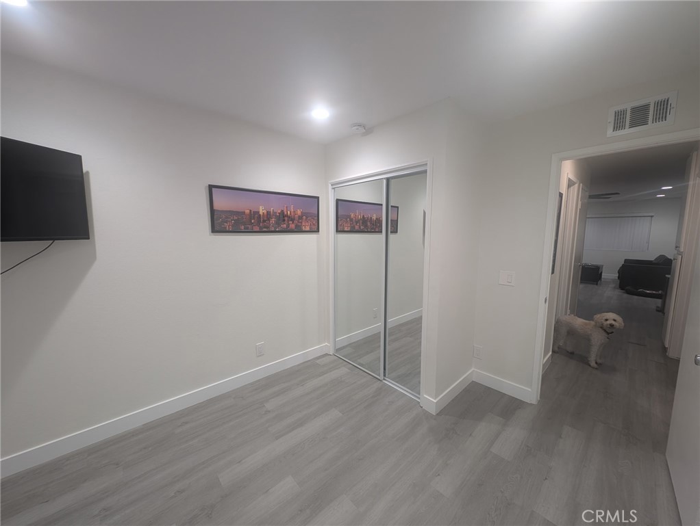 1723 Normandy Place, Unit D Santa Ana, CA 92705 - Photo 10 of 18 an empty room with wooden floor and windows