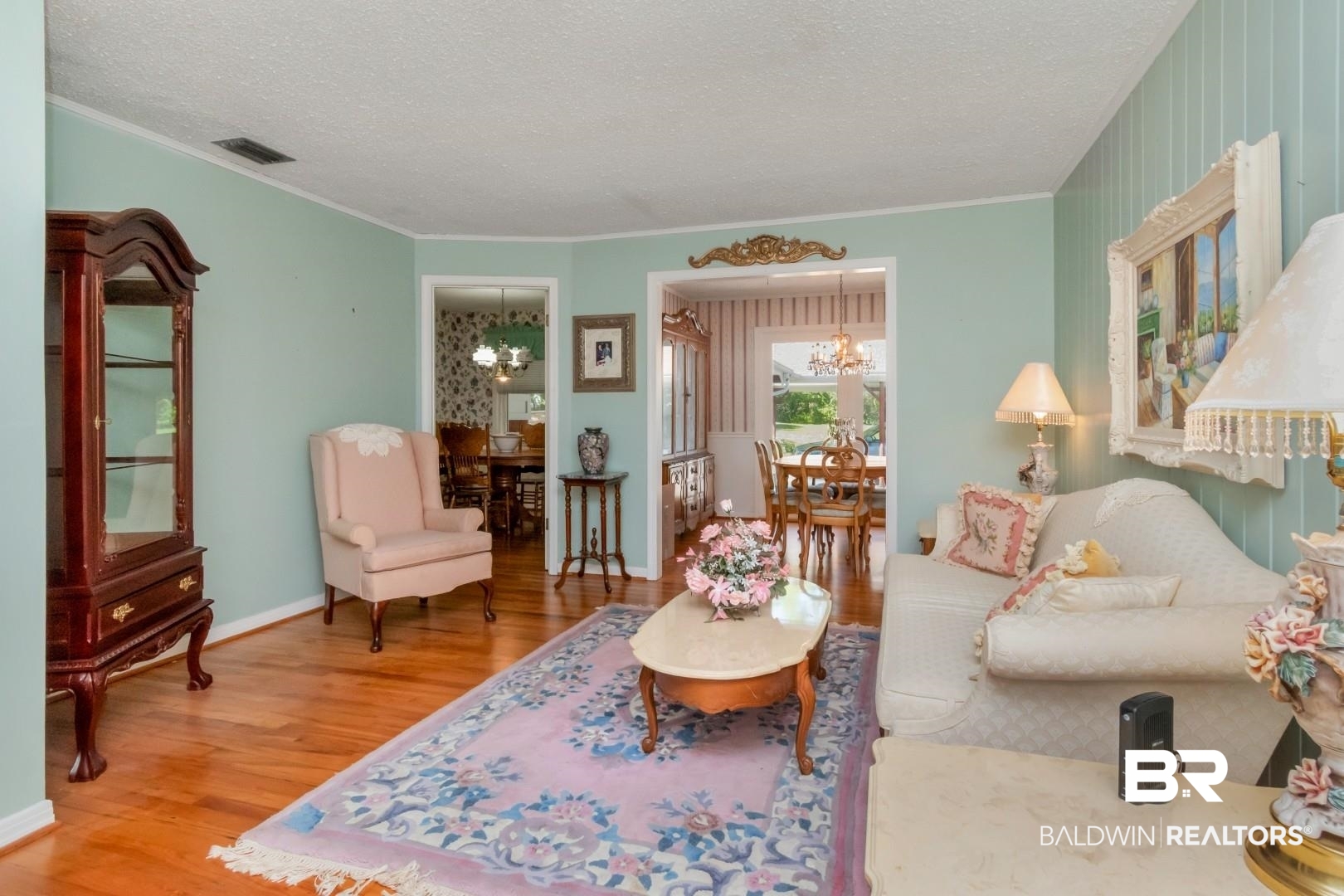 6300 Woodcrest Drive Mobile, AL 36608 - Photo 3 of 35 Living area featuring an inviting chandelier, ornamental molding, a textured ceiling, visible vents, and wood finished floors
