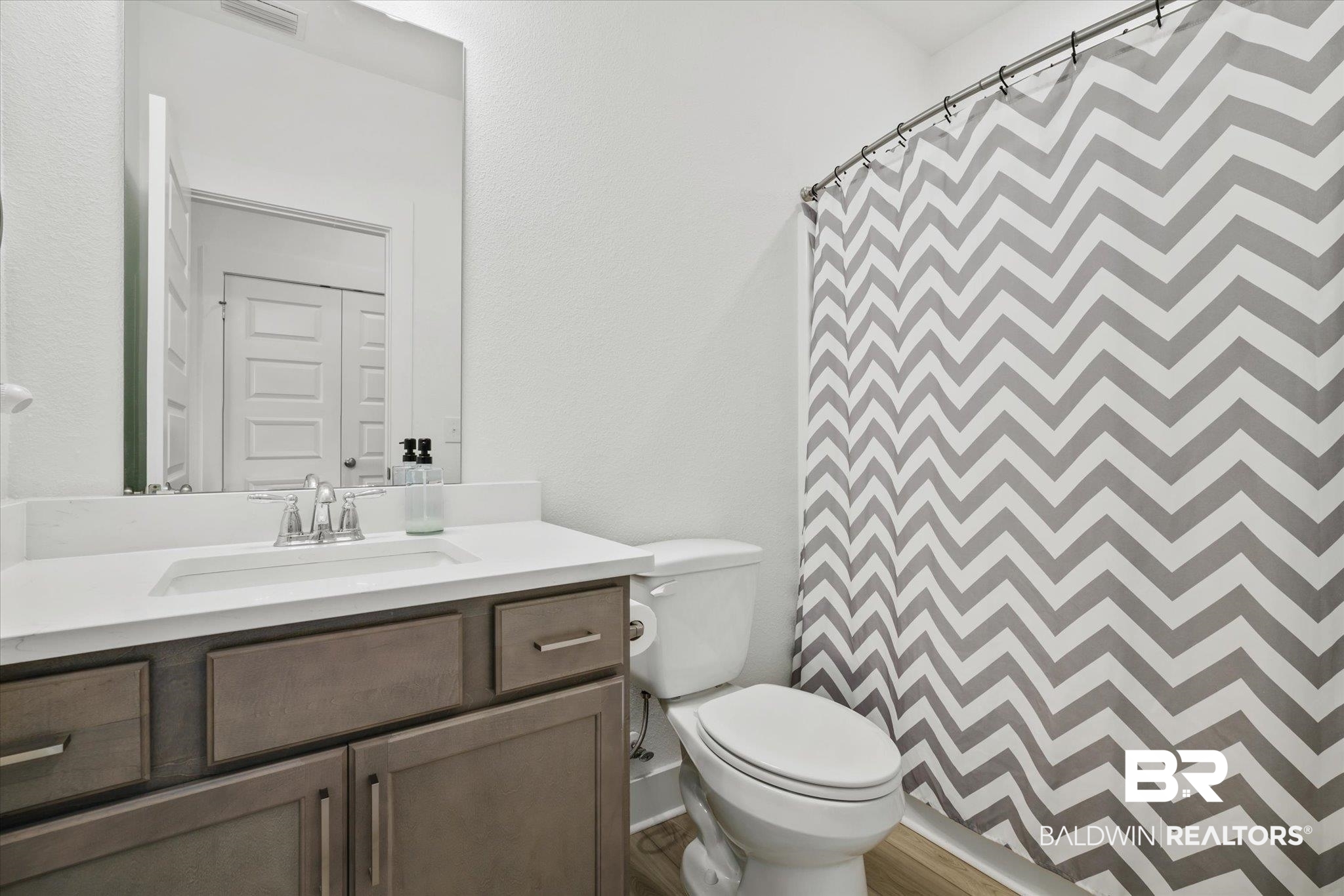 263 Bronze Street Fairhope, AL 36532 - Photo 27 of 47 Bathroom with vanity, toilet, hardwood / wood-style floors, and curtained shower