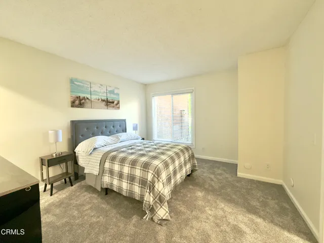 a bedroom with a bed and a painting on the wall