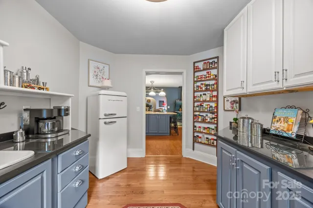a kitchen with granite countertop a refrigerator and cabinets