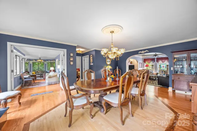 a view of a dining room with furniture a chandelier and wooden floor