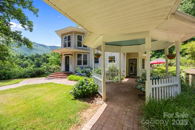 an aerial view of residential house with outdoor space and trees all around