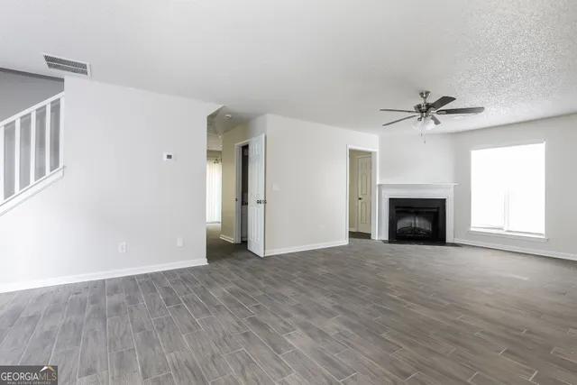 wooden floor fireplace and windows in an empty room