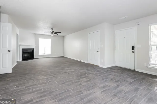 a view of an empty room with a fireplace and a window