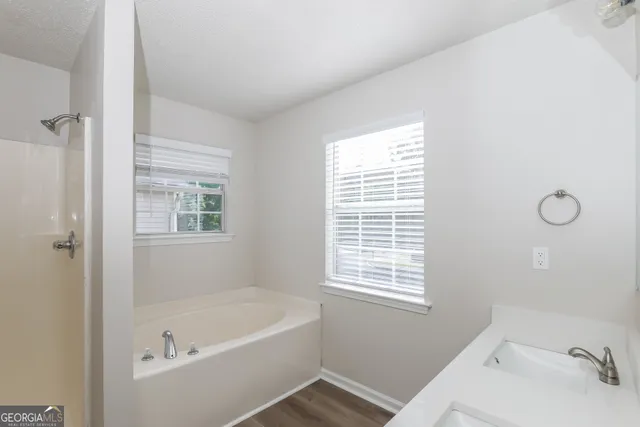 a bathroom with a tub sink and a window