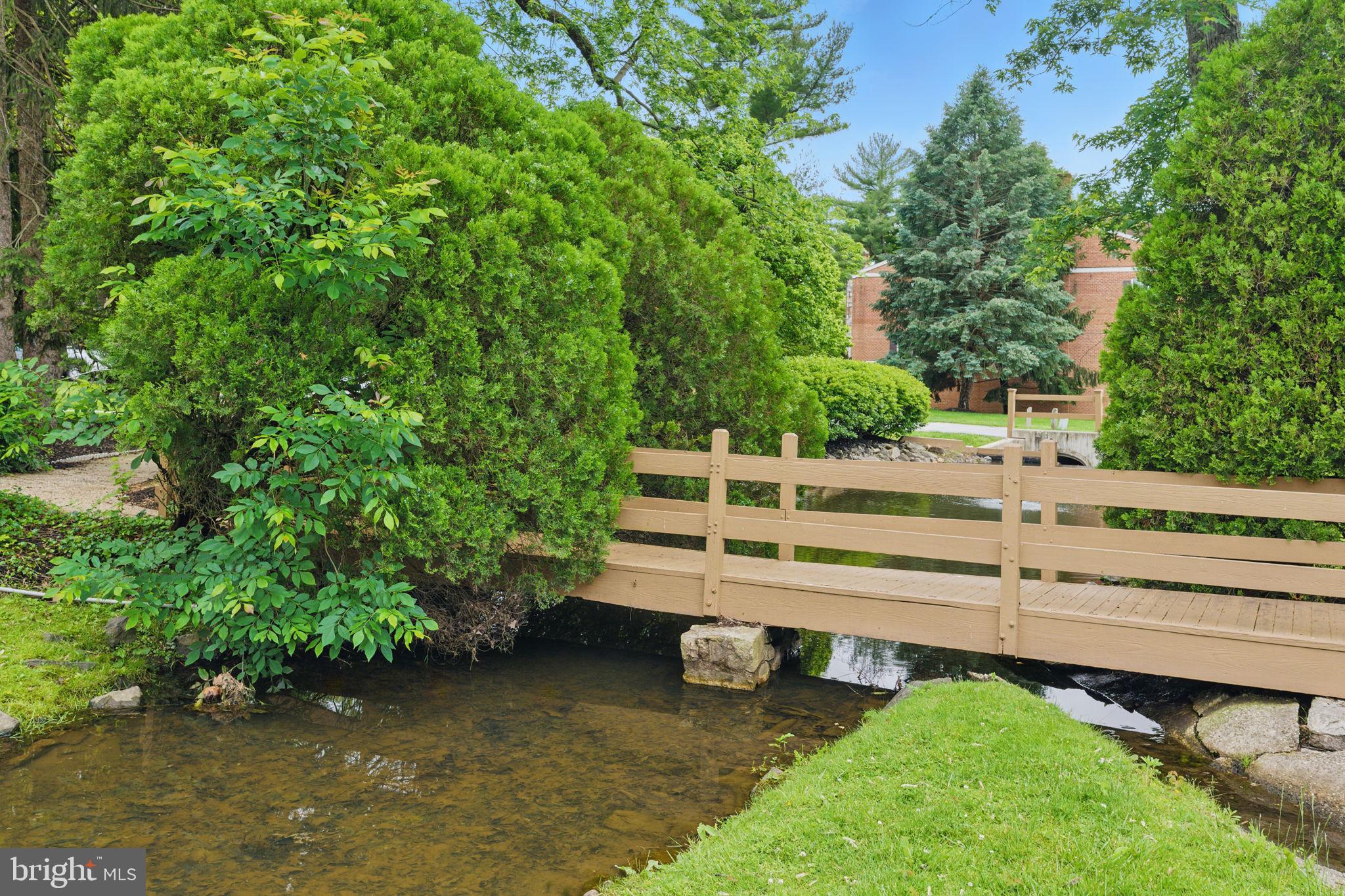 288 Drummers Lane, Unit 288 Wayne, PA 19087 - Photo 27 of 30 a view of a wooden bench and trees in the backyard