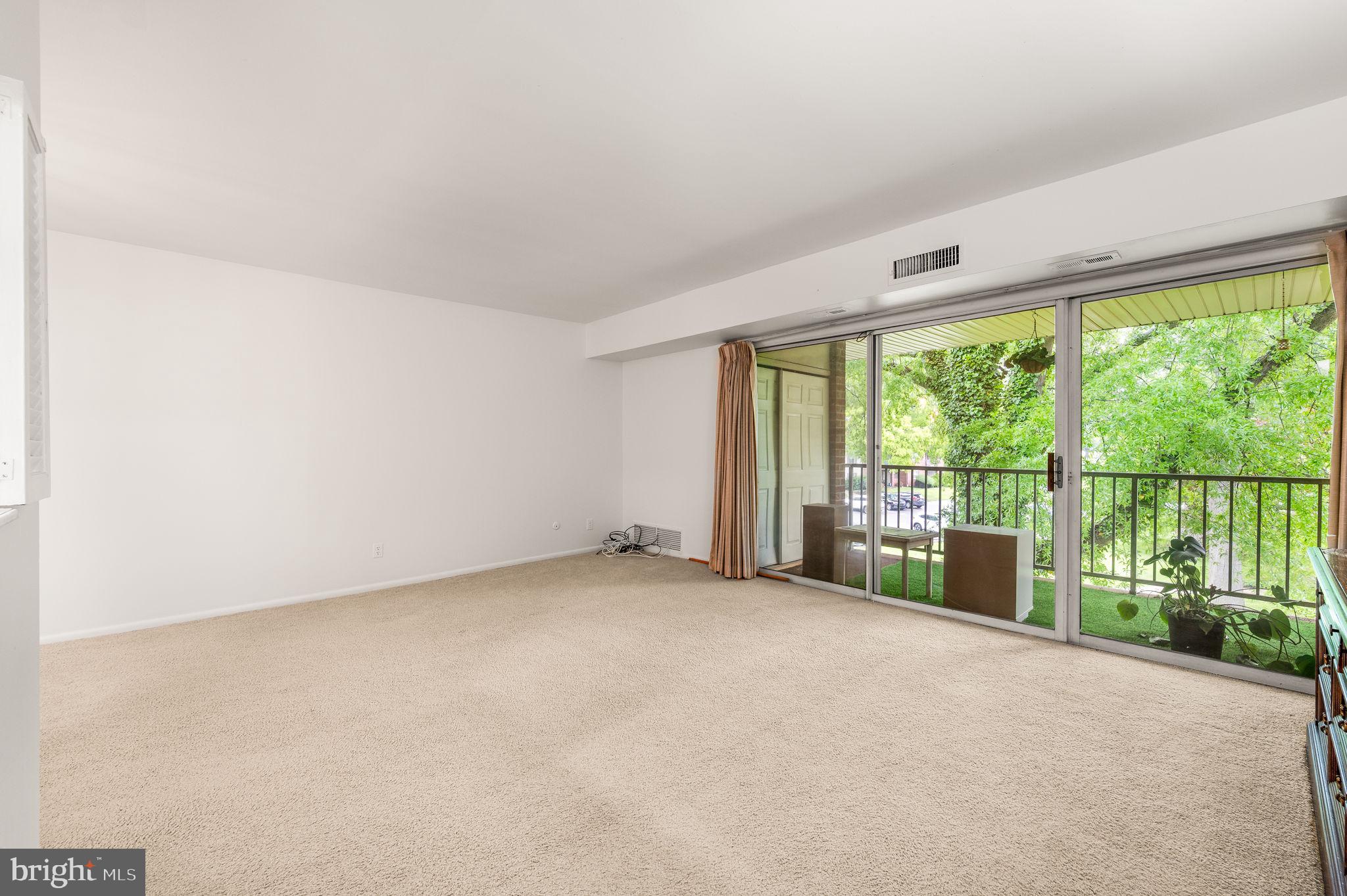 288 Drummers Lane, Unit 288 Wayne, PA 19087 - Photo 7 of 30 an empty room with large windows and view of balcony