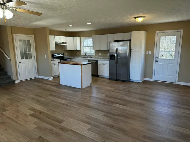 a kitchen with stainless steel appliances granite countertop a refrigerator and a stove