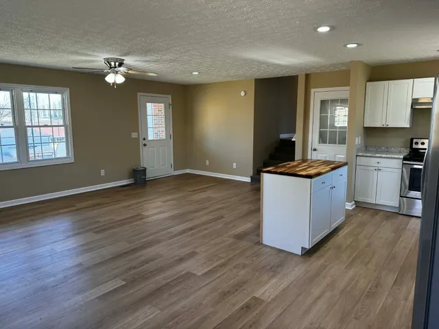 a kitchen with granite countertop a sink and a stove top oven