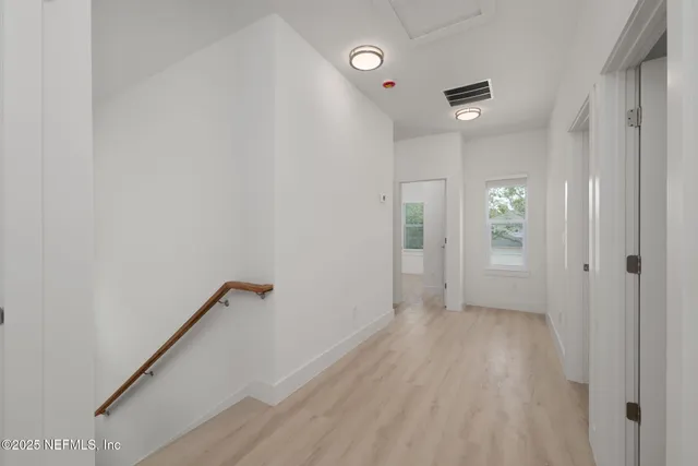 a view of a hallway with wooden floor