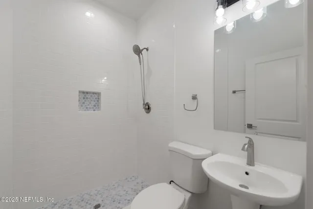 a bathroom with a toilet a sink and mirror