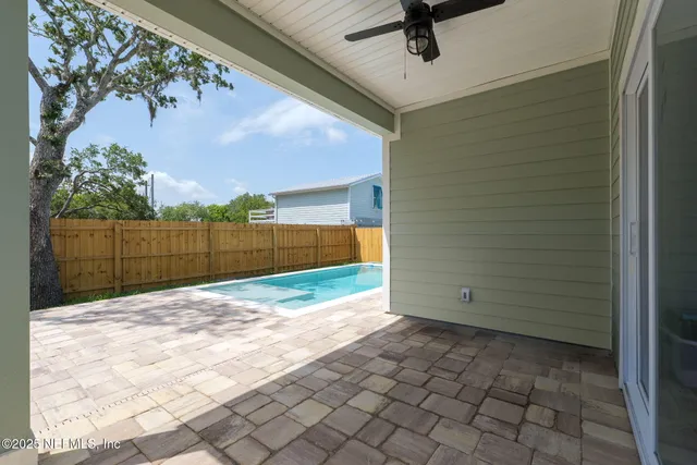 a view of backyard with wooden fence
