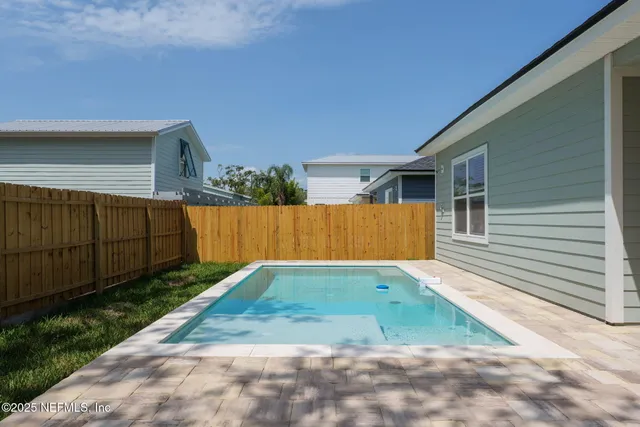a view of backyard with small cabin and wooden fencing