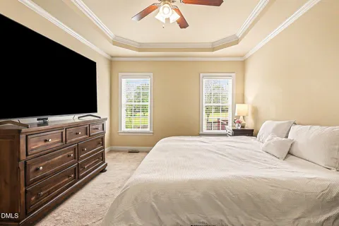 a bedroom with a bed and a flat tv screen on a dresser