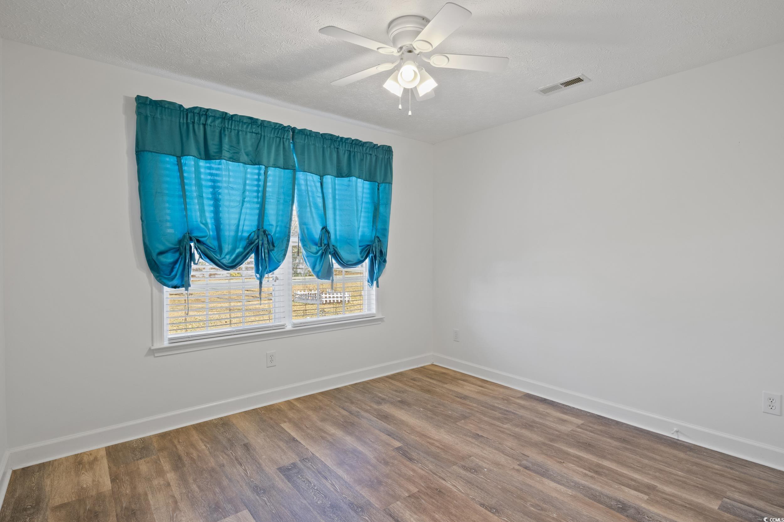 5933 Rahnavard Boulevard Myrtle Beach, SC 29588 - Photo 12 of 25 Empty room with ceiling fan, a textured ceiling, a