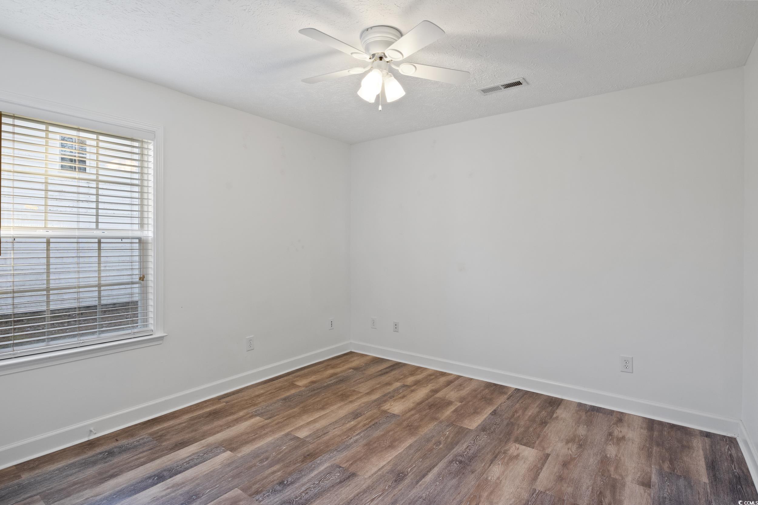 5933 Rahnavard Boulevard Myrtle Beach, SC 29588 - Photo 13 of 25 Spare room featuring ceiling fan, a textured ceili