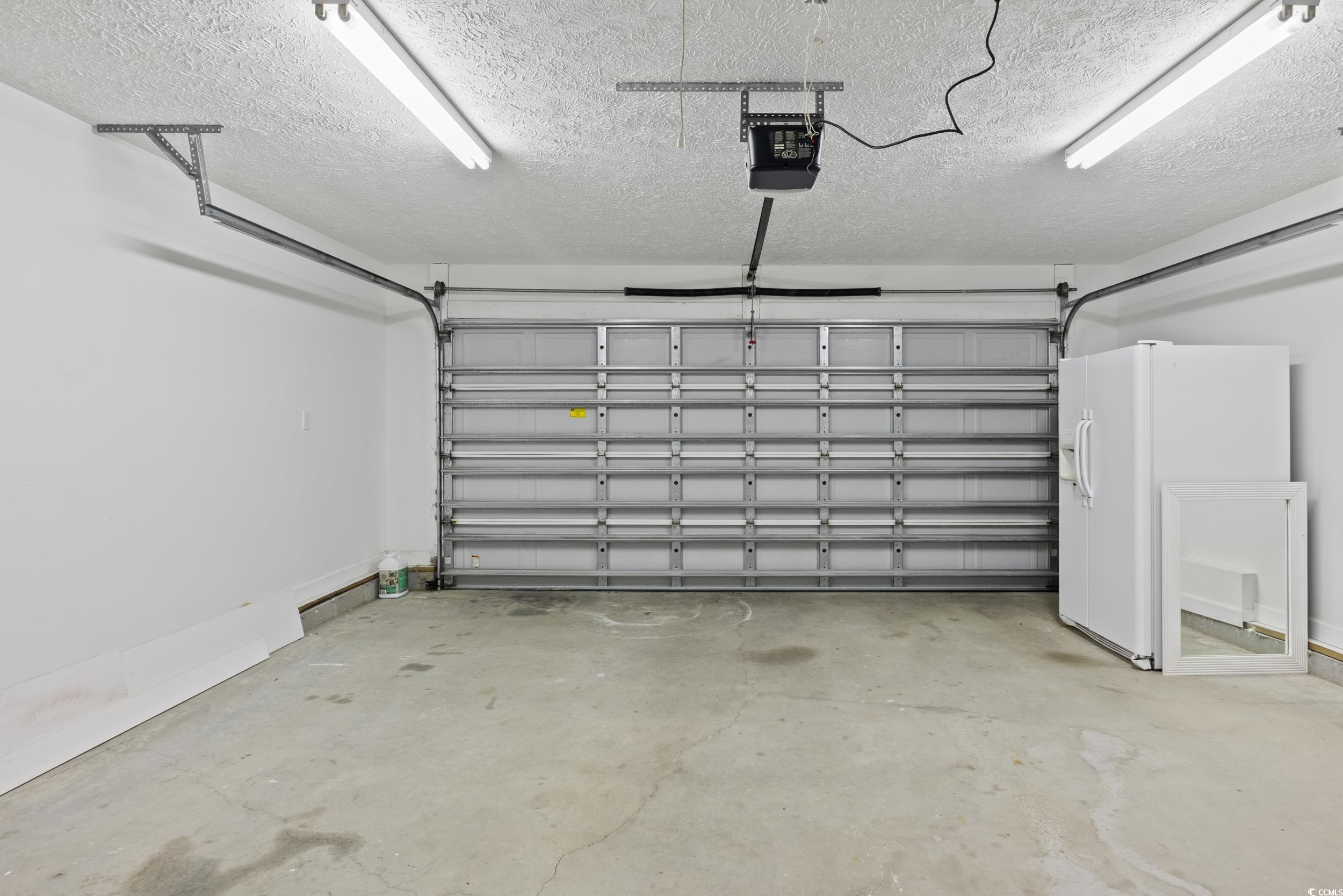 5933 Rahnavard Boulevard Myrtle Beach, SC 29588 - Photo 23 of 25 Garage featuring a garage door opener and white re