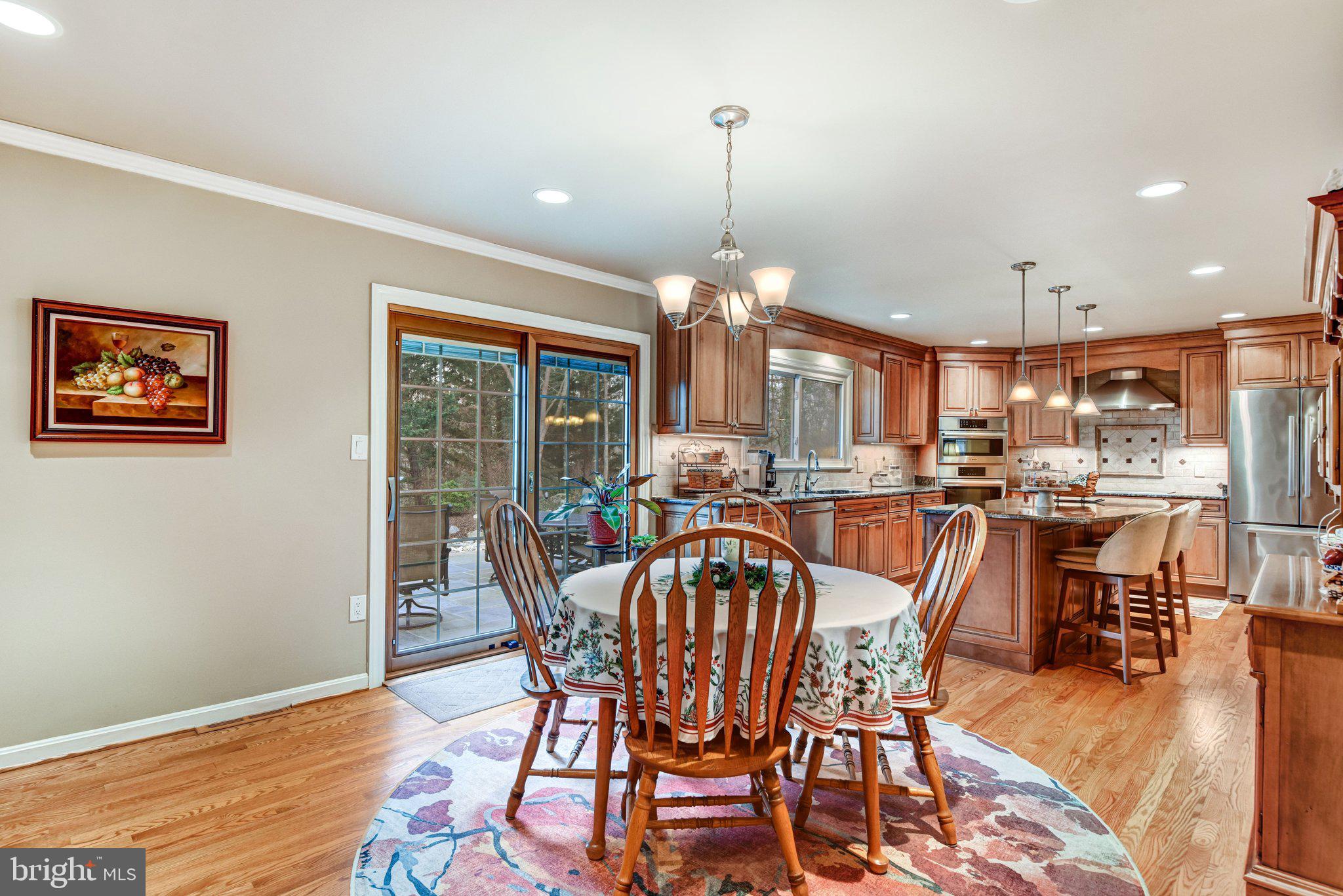 10111 Evans Ford Road Manassas, VA 20111 - Photo 10 of 35 a view of a dining room and livingroom with furniture wooden floor a rug a painting and a chandelier