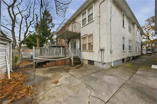 a view of a house with backyard and wooden fence
