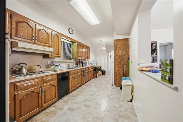a large kitchen with stainless steel appliances granite countertop a sink and cabinets