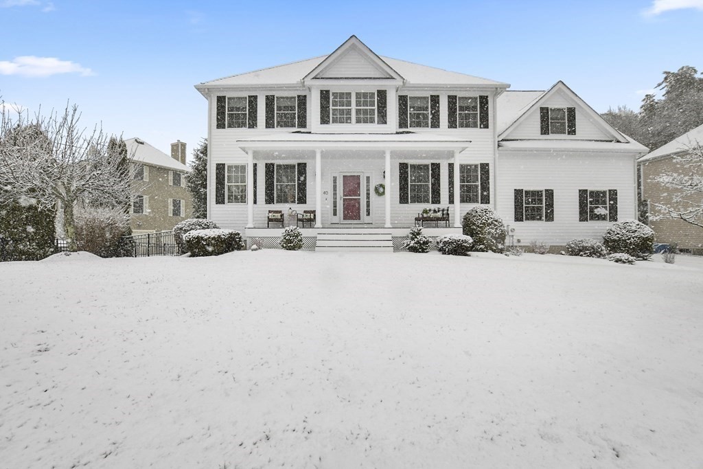 a front view of a house with a yard covered in snow
