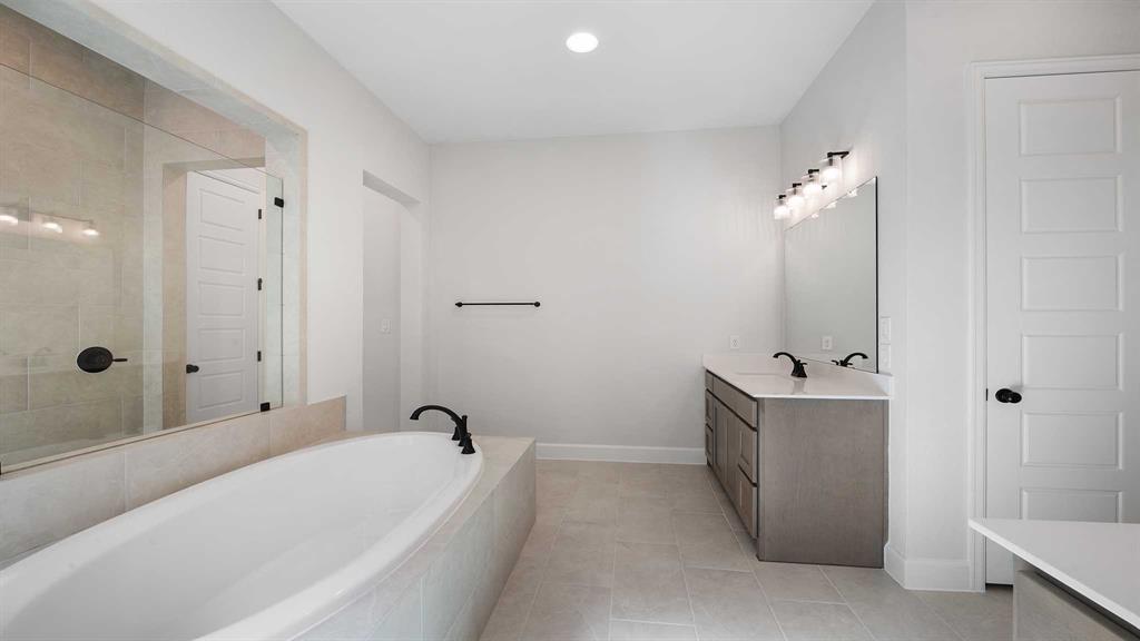 1104 Barnmeadow Lane Forney, TX 75126 - Photo 18 of 33 a bathroom with a tub a sink and mirror
