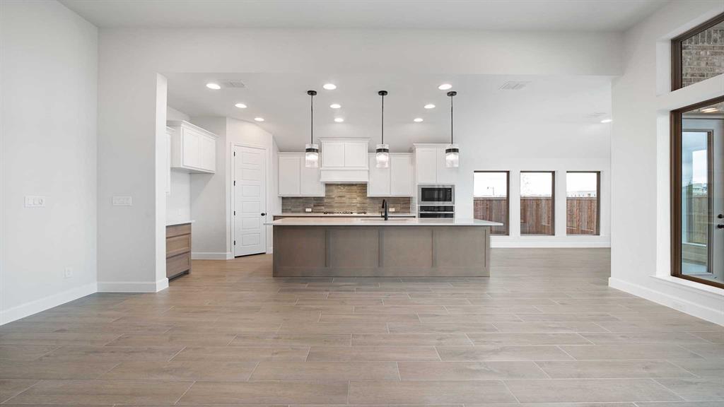 1104 Barnmeadow Lane Forney, TX 75126 - Photo 8 of 33 a large kitchen with a large counter top stainless steel appliances and cabinets