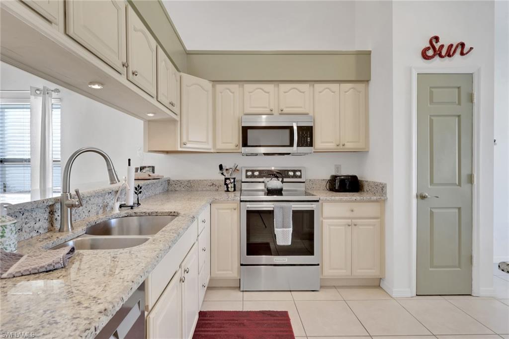 841 Kings Way Naples, FL 34104 - Photo 11 of 43 Kitchen featuring stainless steel appliances, light tile patterned floors, and light stone countertops
