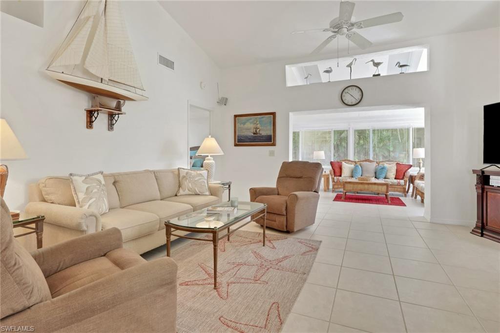 841 Kings Way Naples, FL 34104 - Photo 13 of 43 Living room featuring light tile patterned flooring, ceiling fan, and a towering ceiling