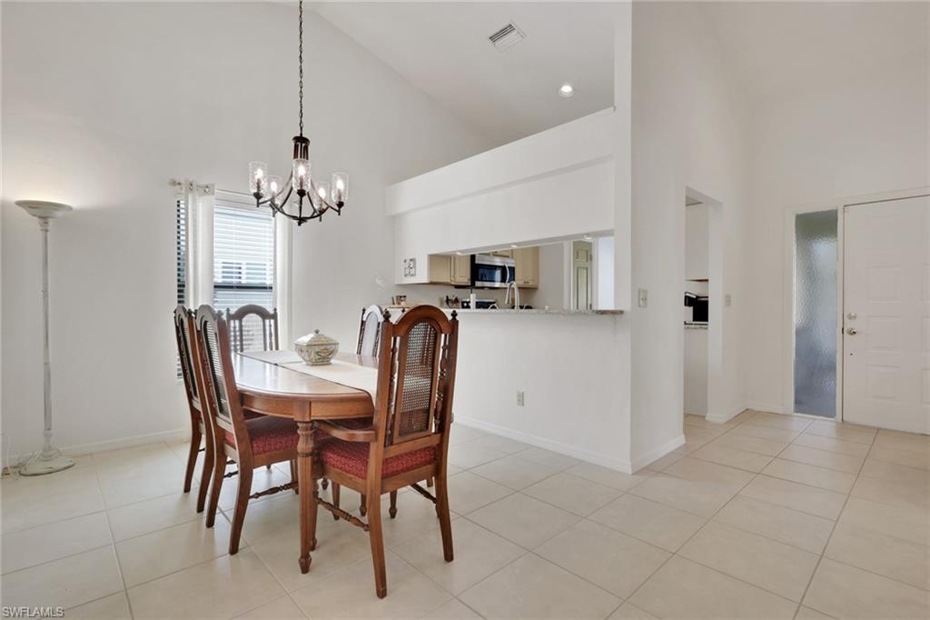 841 Kings Way Naples, FL 34104 - Photo 9 of 43 Dining area with high vaulted ceiling, light tile patterned floors, and a chandelier