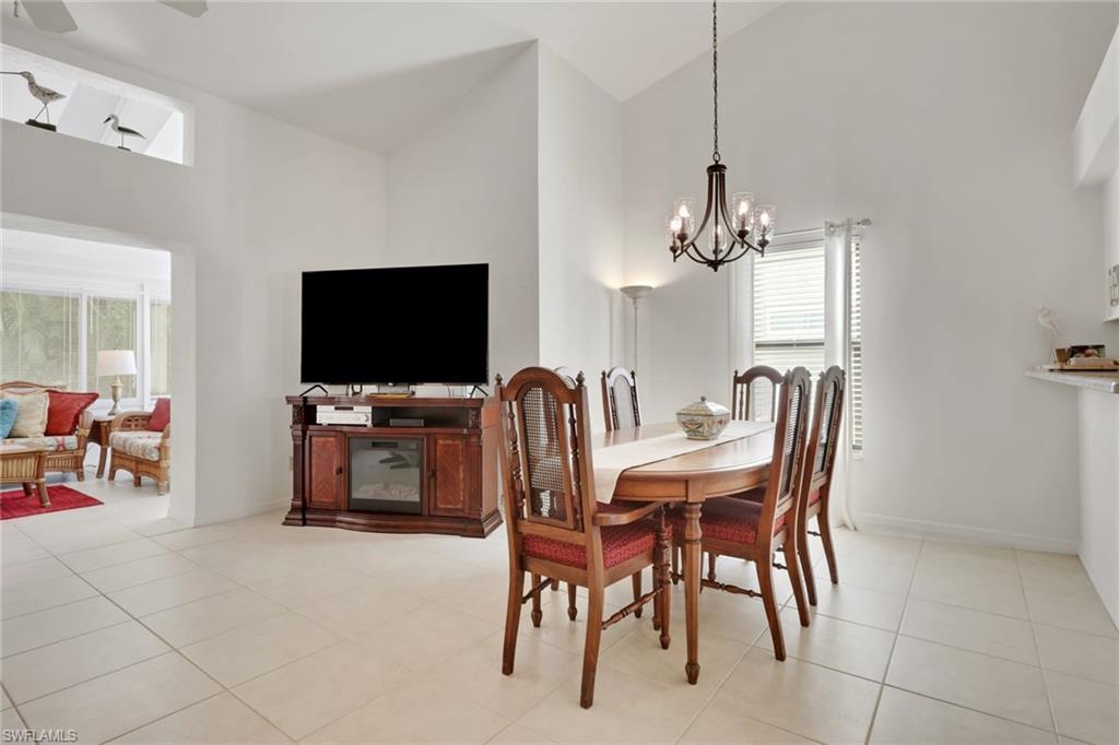 841 Kings Way Naples, FL 34104 - Photo 10 of 43 Dining space featuring high vaulted ceiling, light tile patterned flooring, and a chandelier
