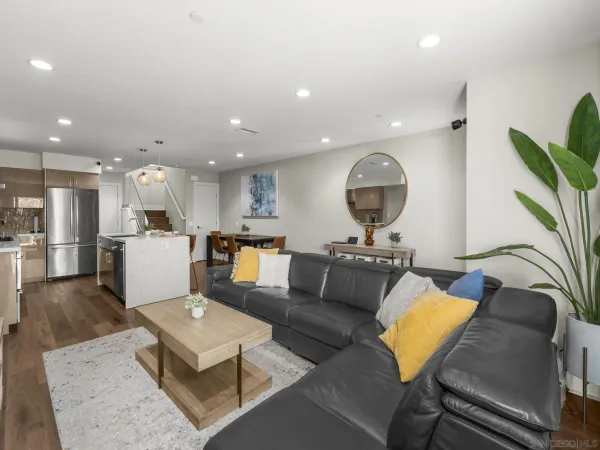 a living room with furniture and a view of kitchen