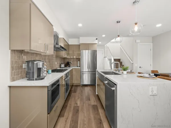a kitchen with stainless steel appliances granite countertop a sink a stove and a refrigerator