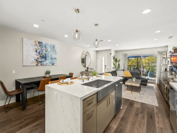 a view of a kitchen with kitchen island a sink dining table and chairs