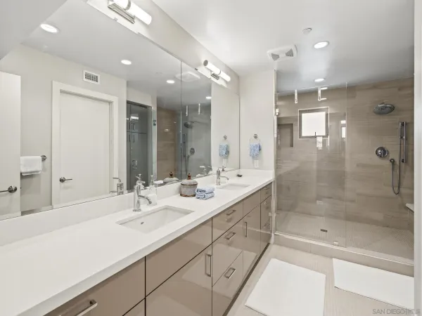 a bathroom with a shower sink double mirror and shower
